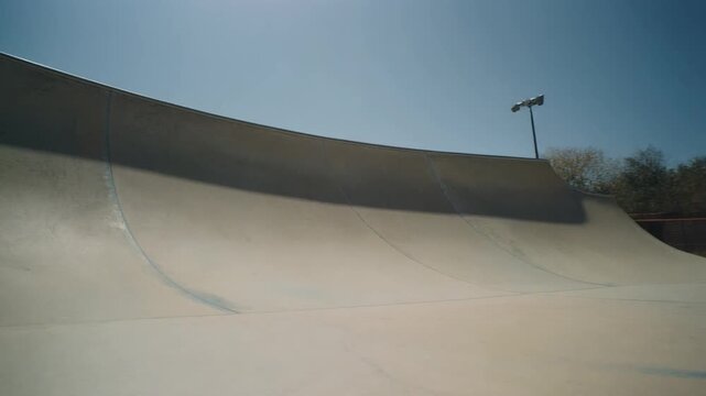 Empty skatepark bowl under clear blue sky