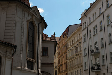 Obraz premium Ancient architecture visible through window, Historic alley with sunlit rooftops viewed from church, Old town scene featuring weathered roofs and sunlightdrenched streets from cathedral window