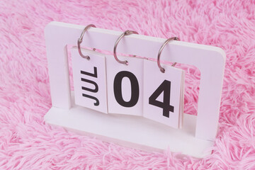 July 4 on calendar on pink carpet background