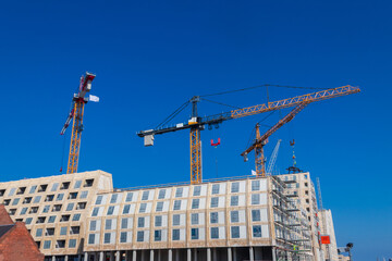Construction site with a towering cranes and modern buildings under a blue sky