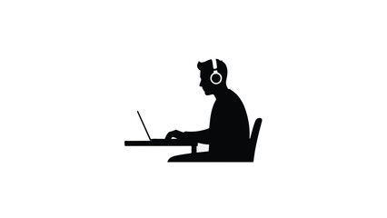 Silhouette of young professional man working on laptop computer at desk.