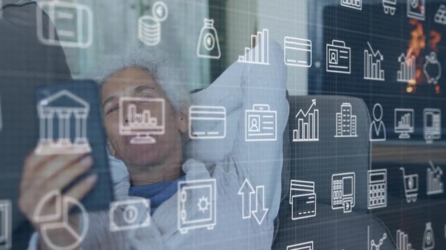 Animation of financial icons over senior woman using smartphone on sofa