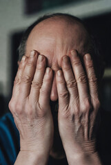 person's hands covering their face, suggesting a state of distress, sadness, or emotional turmoil. The hands are covering the eyes and forehead, creating a sense of hiding or concealing one's emotions