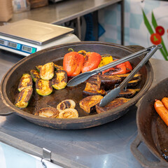 Grilled vegetables in rustic pan: peppers, zucchini, eggplant, onions on market stall