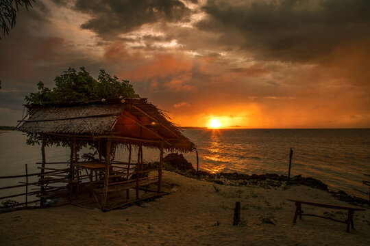 Tropical nipa hut on cliffs, beach hut on the beach at sunset
