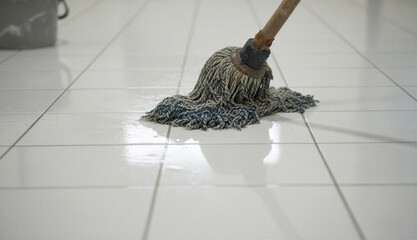 Mop on a tiled floor next to a bucket