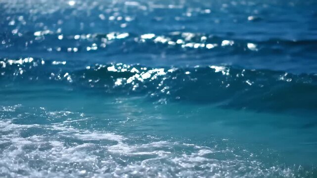 This mesmerizing close-up captures the dynamic beauty of ocean waves gently breaking with white foam. Sunlight brilliantly reflects and sparkles on the deep blue and vibrant turquoise water surface, c