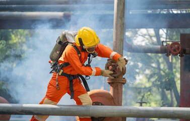 firefighter in an orange jumpsuit is working on  pipe