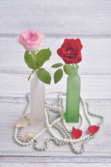 Valentines day card. Red and pink rose in vase, with white pearls.