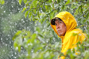 Man in yellow raincoat faces storm while surrounded by trees in the outdoors Generative AI