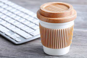 Coffee cup with bamboo lid next to a keyboard in a cozy workspace setting Generative AI