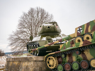 World War II tank monument near Kapišová, Slovakia. Preserved Soviet and German tanks displayed outdoors, with a tank gun pointing directly toward the camera in a rural winter landscape.