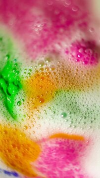 Colorful bubbly liquid with a green object resembling a skull or alien head