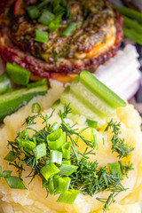 Baked meat with cheese and mashed potatoes with fresh vegetables as a side dish
