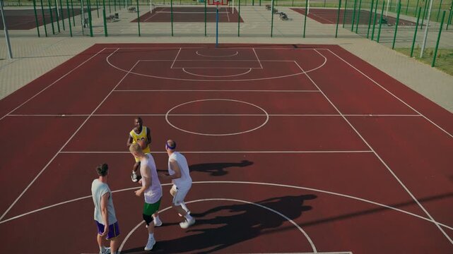 Top view of a player scoring a three-pointer. The basketball players play on the court.