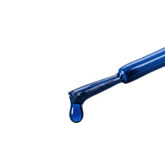 Glistening sapphire blue viscous liquid drop suspended from a black nail polish brush, macro, extreme close-up on transparent studio background with copy space. Concept for luxury cosmetic