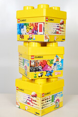 Obraz premium Minsk, Belarus - September 10, 2025: Lego Classic building blocks stacked in vibrant yellow boxes on a white background, showcasing creativity and imaginative play with copy space