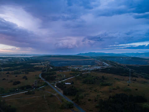 Coal mining and export infrastructure seen from aerial view at dusk on overcast evening