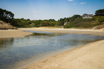 View of Anse de Rospico, a beach surrounded by green cliffs that gets flooded by tide. Nevez, Finistere, Brittany, France. No people.