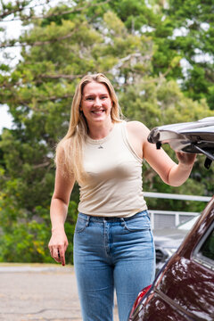 young woman closing the hatch on her car