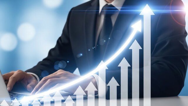 A businessman in a suit typing on a laptop with a glowing upward arrow and bar graphs symbolizing financial growth and success. - Powered by Adobe