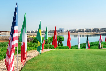 Golf flags on display by the water at a luxury course in bright weather