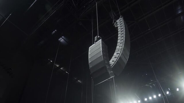 Decorative details made of sections hang over concert stage. Installing minimalist construction under frame ceiling in hall lit by lamps