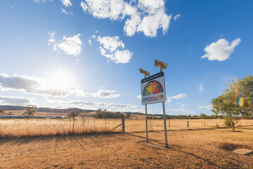 Extreme fire danger risk warning sign on total fire ban day in rural New South Wales with sunflare