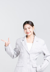 Confident young asian businesswoman smiling and presenting with finger pointing gesture, Professional woman and corporate female leader isolated on white background.
