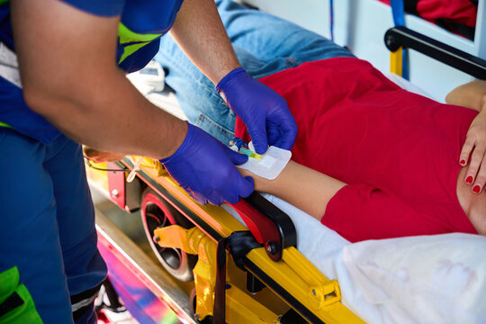 Male doctor performing emergency IV treatment in ambulance