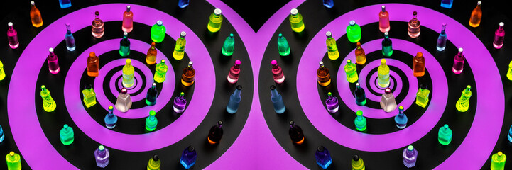 a display of colorful, miniature decorative bottles are arranged on a surface with a black and purple endless hypnotic spiral