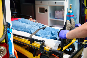 Healthcare worker moving patient into ambulance © Svitlana