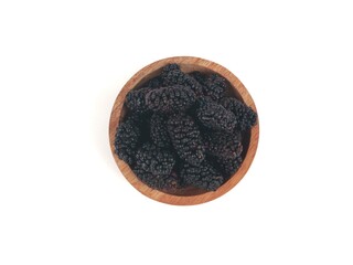 Fresh ripe black mulberries in a wooden bowl isolated on white background. Perfect for healthy eating, organic food, and harvest themes. Top view 