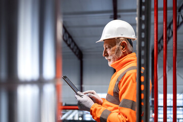 Senior engineer using tablet in industrial facility