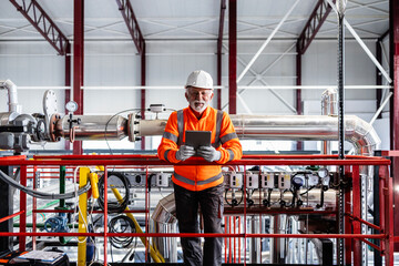 Senior engineer working with tablet in industrial facility