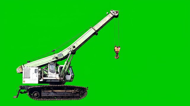 A heavy-duty crawler crane extends its boom and lifts its hook on a green screen background