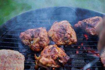 cosce di carne di pollo mentre vengono cucinate su una griglia