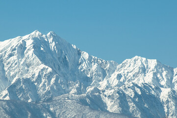 Obraz premium Close-up of snow-covered mountain peaks in Northern Alps with clear blue sky, majestic winter alpine scenery