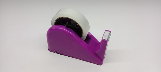 Close-up of clear duct tape with purple dispenser on white background