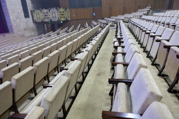 An empty concert hall with light-colored seats
