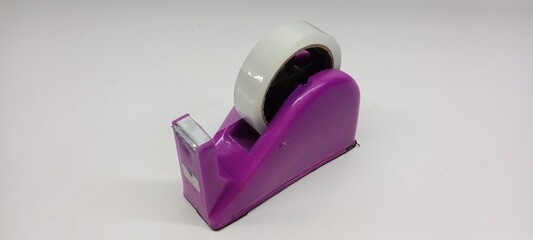 Close-up of clear duct tape with purple dispenser on white background