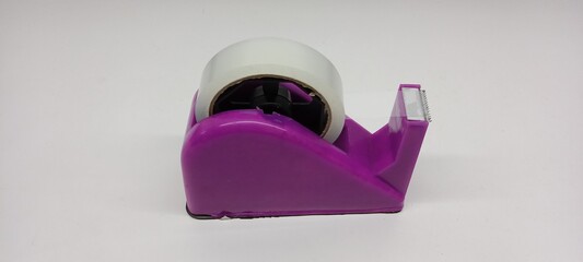 Close-up of clear duct tape with purple dispenser on white background