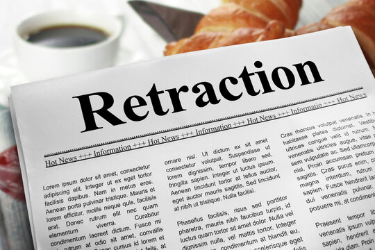 Retraction in newspaper layout on a breakfast table with a blurry cup of coffee and croissants in the background.
