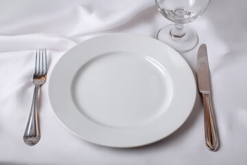 Vibrant photo of Empty white plate with silver cutlery and glass on a white linen tablecloth