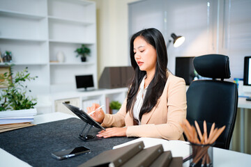 Businesswoman working at digital tablet in office