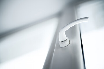 White locking handle on a modern uPVC window sash. Close-up concept of home renovation, hardware repair, and energy efficient double glazing. Photo