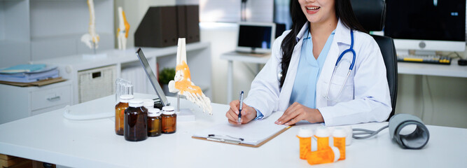 Smiling female doctor working with document for paperwork while sitting at desk in modern hospital office, healthcare and technology concept