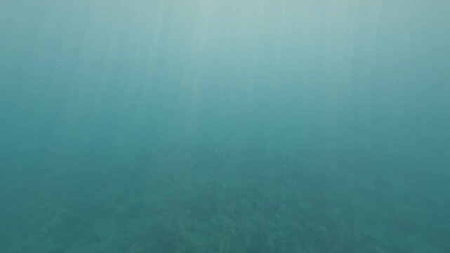 Peaceful underwater view of clear Mediterranean seabed with light rays.