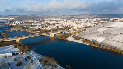 Snow covered Moselle valley, vineyard and Mosel river, Viaduct Longuich bridge of highway crossing...