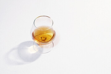 Natural cognac in a glass on a light background